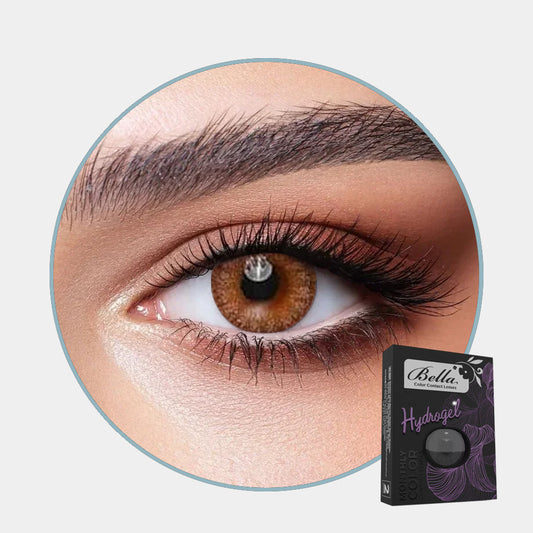 Close-up of an eye with a oak color contact lens and a box labeled 'Bella Hydrogel' on a light gray background