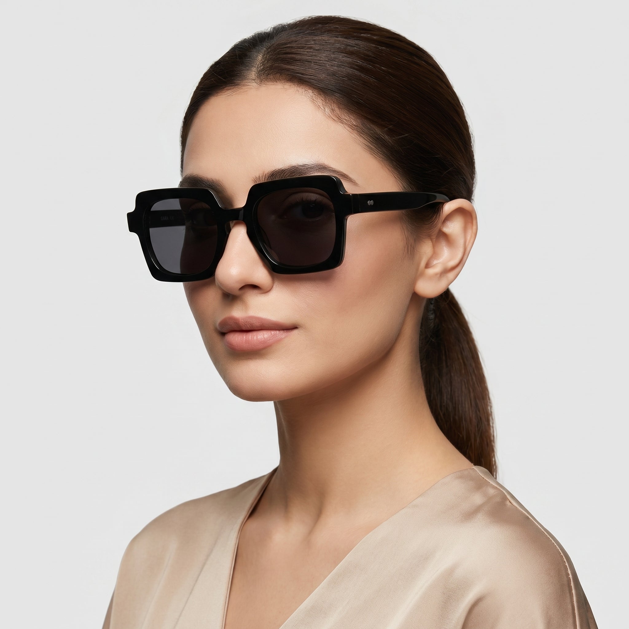 Woman wearing black sunglasses with a plain background